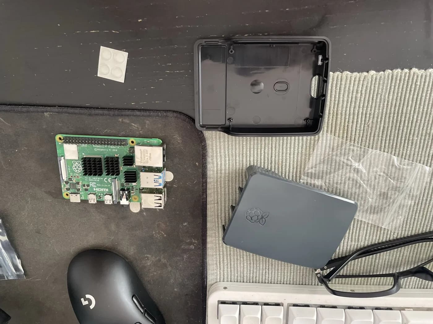 Raspberry Pi z radiatorami obok elementów obudowy na biurku